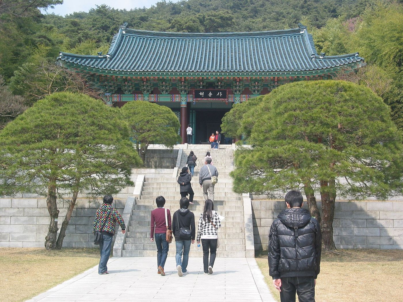 현충사 본전 — 이순신 장군의 영정을 모신 사당으로, 소나무 길을 따라 계단을 오르면 산자락을 등지고 단정하게 선다