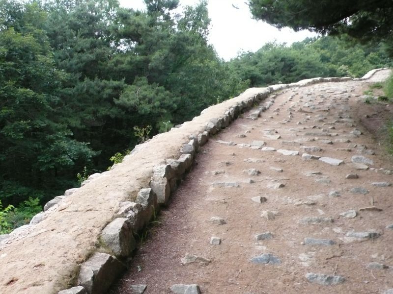 상당산성 성곽길 — 능선을 따라 돌로 쌓은 성벽이 이어지고, 그 너머로 숲과 하늘이 트인다