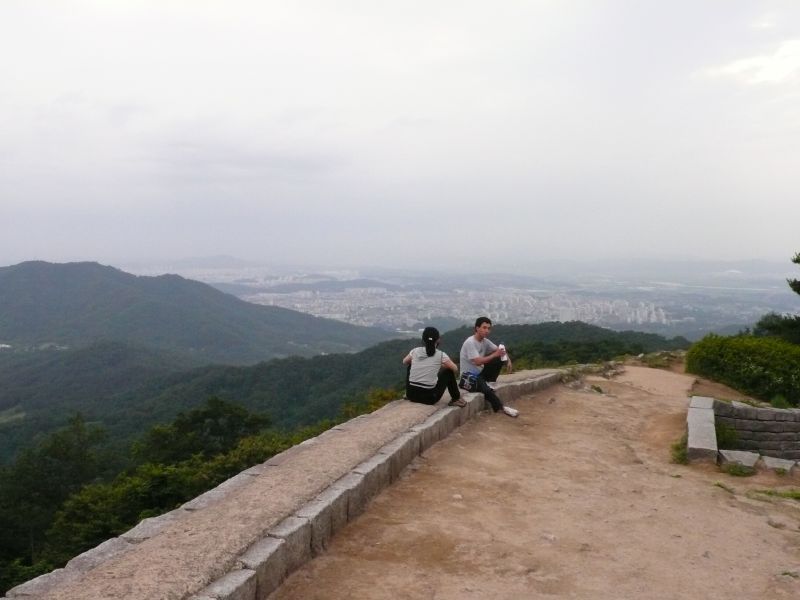 상당산성 성벽길에서 내려다본 청주 — 능선을 두른 돌성 너머로 시가지가 한눈에 펼쳐진다
