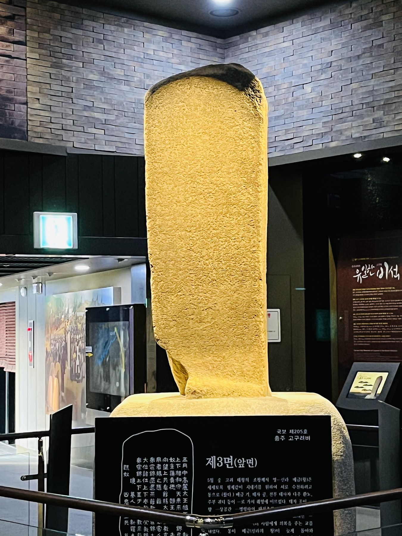 고구려비 전시 공간 — 비석과 함께 비면의 글자를 풀어 주는 안내 해설이 놓였다