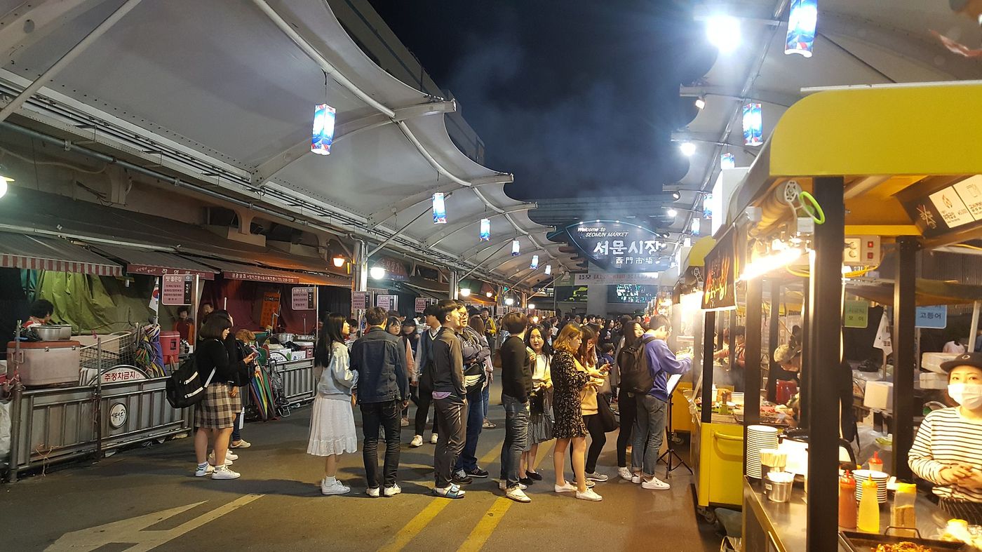 서문시장 야시장 — 저녁에만 열리는 먹거리 골목에 줄을 선 사람들 너머로 김이 모락모락 피어오른다