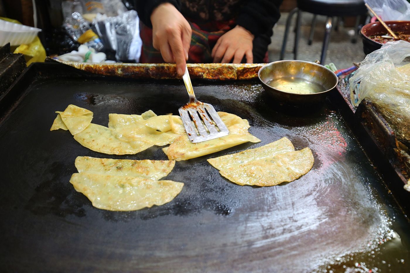 서문시장 좌판에서 부치는 납작만두 — 달군 철판에 얇은 만두를 지져 즉석에서 부쳐 낸다