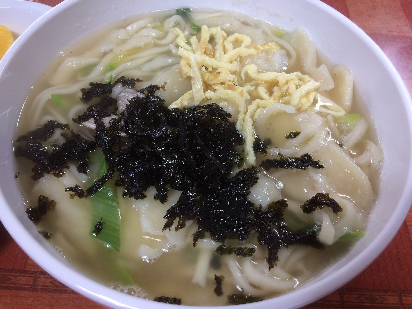 김과 계란지단·바지락을 올린 칼국수 한 그릇 — 손으로 민 굵은 면이 국물을 머금는다