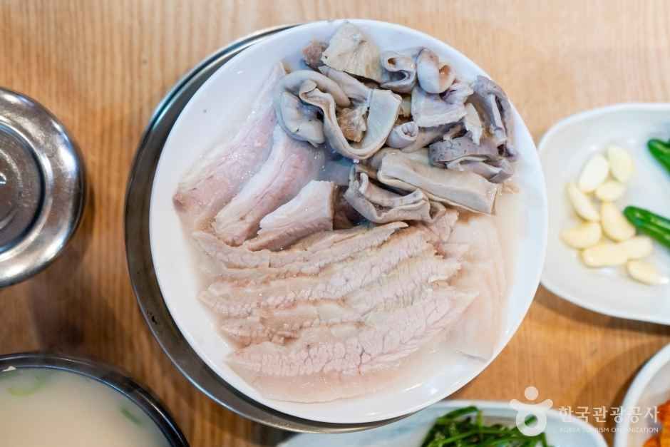 진하게 곤 육수에 푸짐히 담은 수육 한 접시 — 오래 끓여 부드러운 고기가 장터국밥의 속을 채운다
