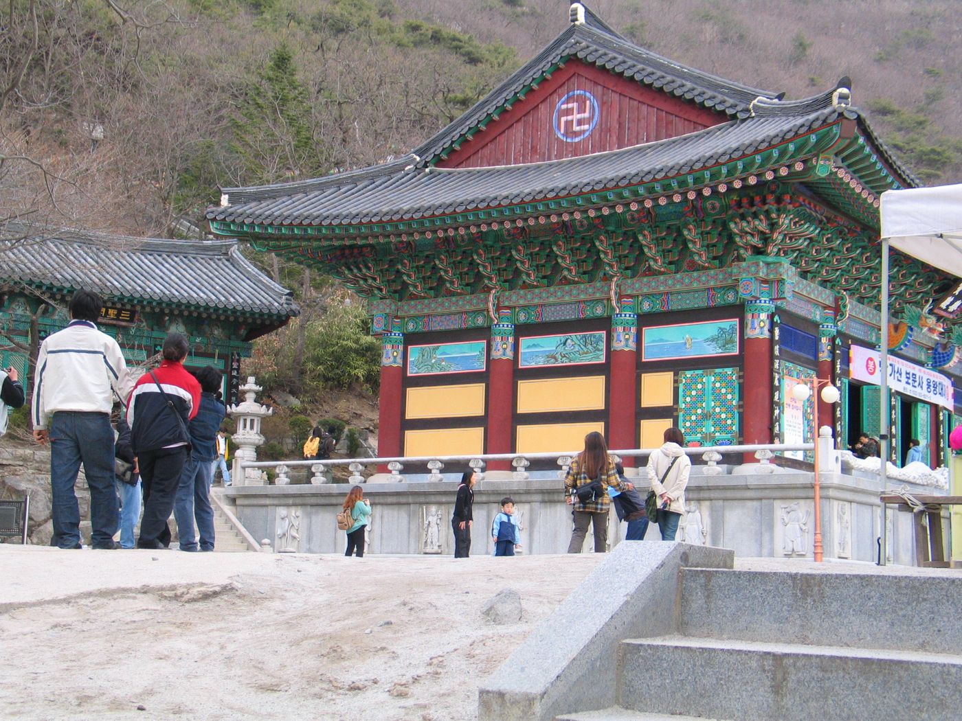 석모도 보문사 극락보전 — 바닷가 산자락에 자리한 관음 기도처를 사람들이 둘러본다