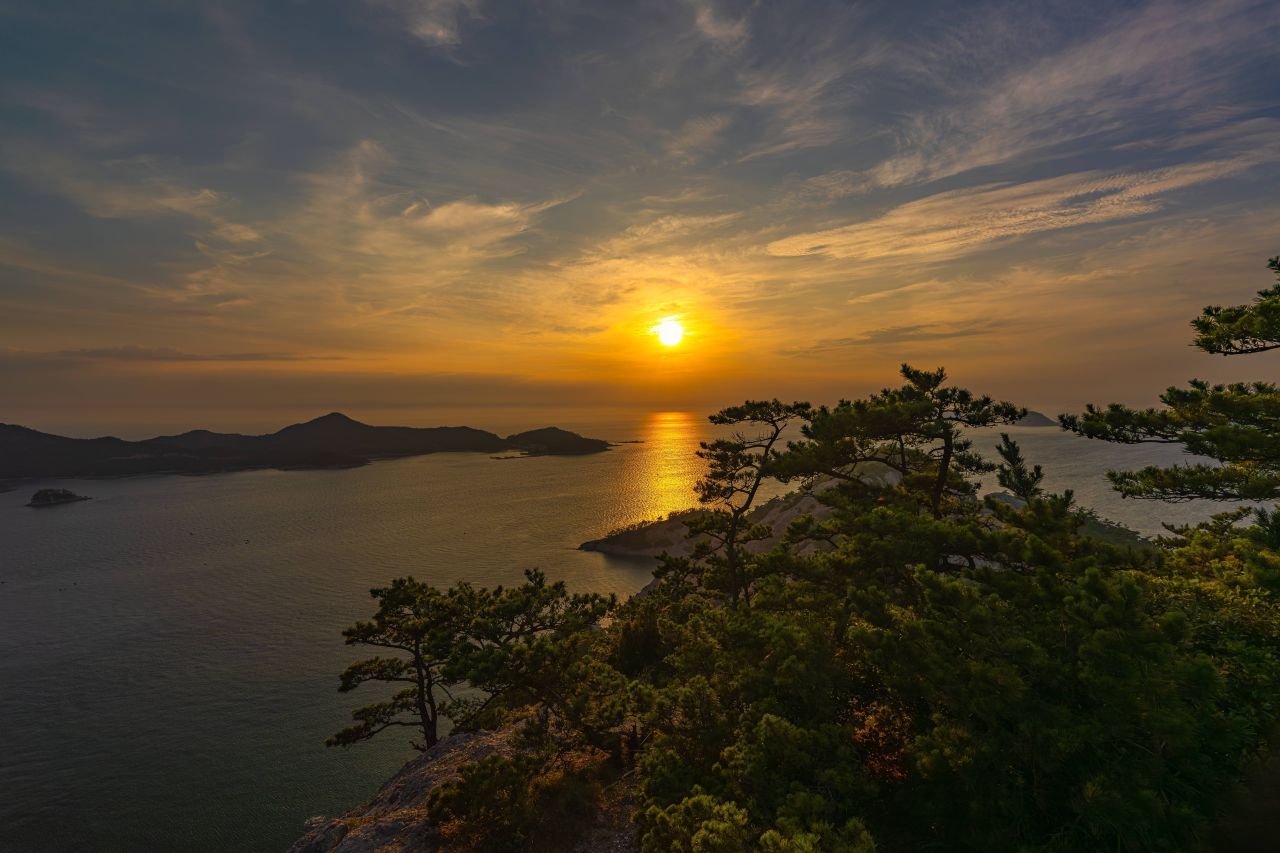 섬 봉우리에서 바라본 일몰 — 소나무 너머로 고군산군도의 섬들과 바다가 펼쳐진다