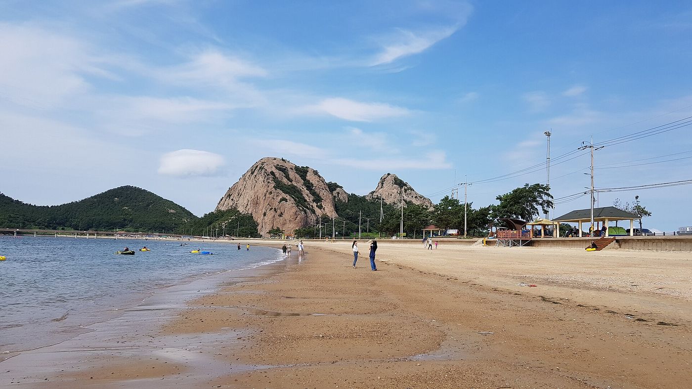 선유도 명사십리 — 망주봉을 배경으로 고운 모래밭이 길게 펼쳐진다. 물놀이를 즐기는 사람들로 여름이면 활기가 돈다