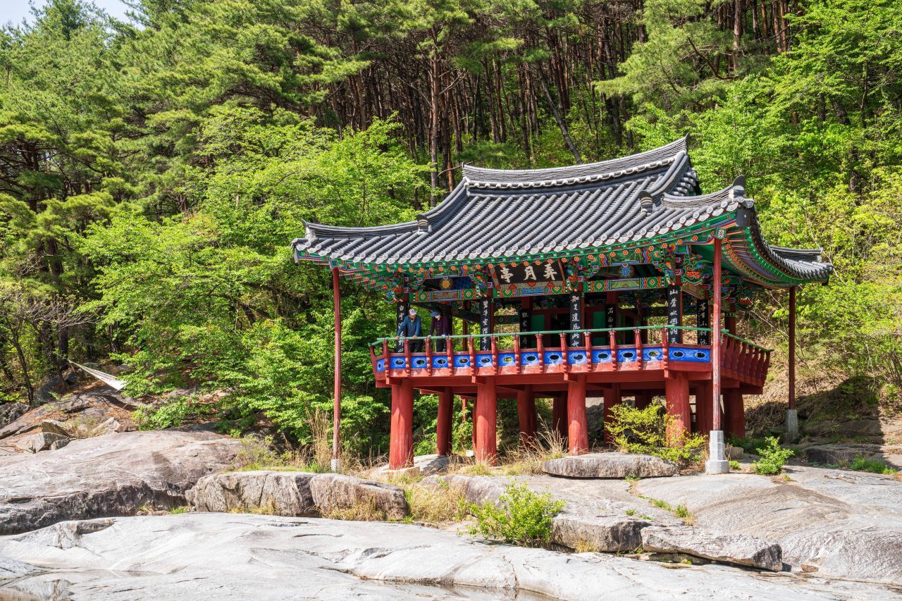 농월정 마루에 올라 계곡을 바라보는 사람들