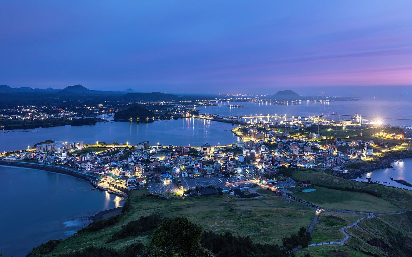 성산일출봉 아래 성산리 마을 — 푸른 어스름에 잠긴 동부 바닷가 풍경