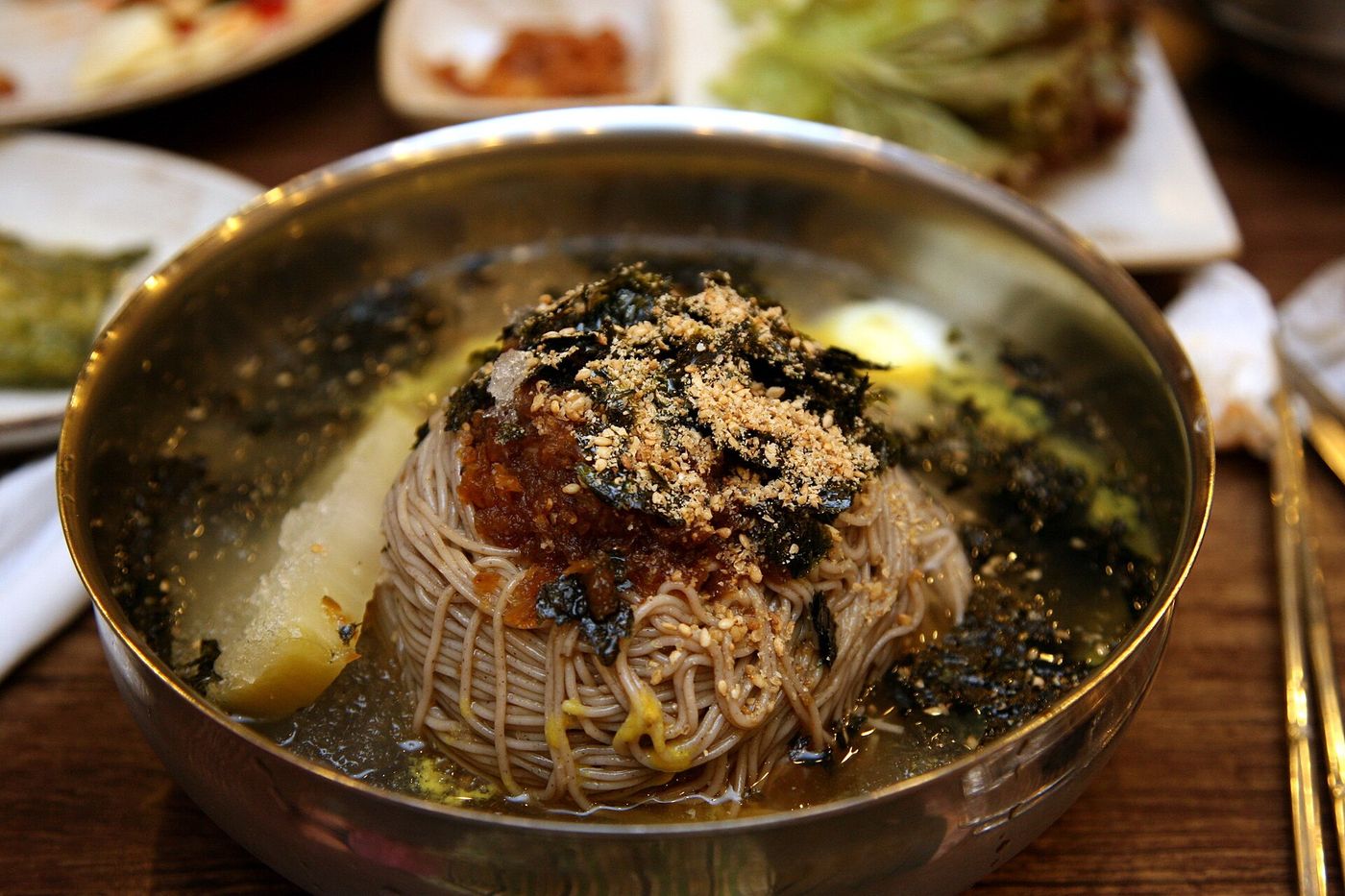 강원식 메밀 막국수 — 메밀로 뽑은 갈색 면에 양념과 김·들깨가루를 얹어 시원하게 비벼 먹는다