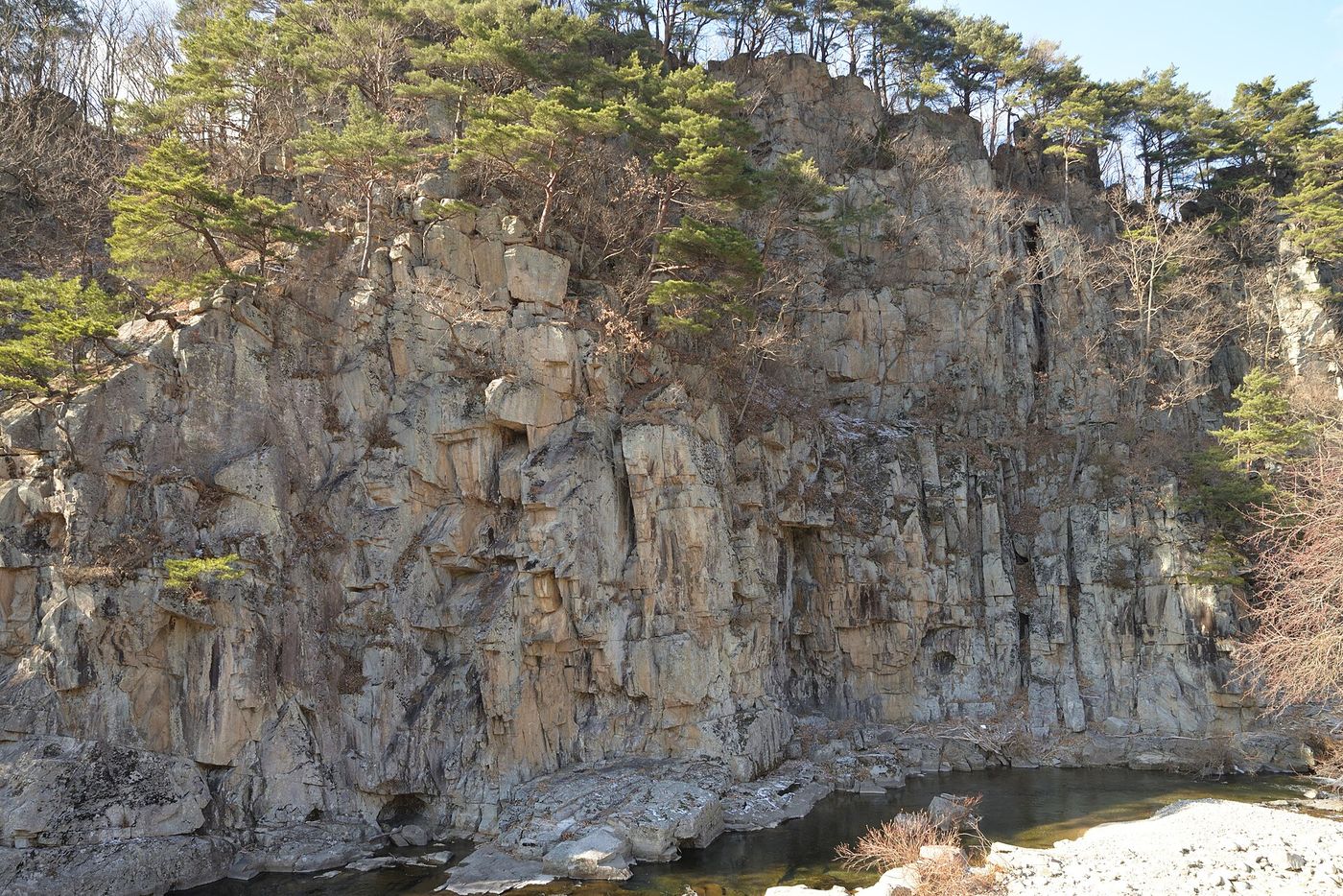 계곡을 막아선 큰 바위 절벽과 그 아래 고인 물