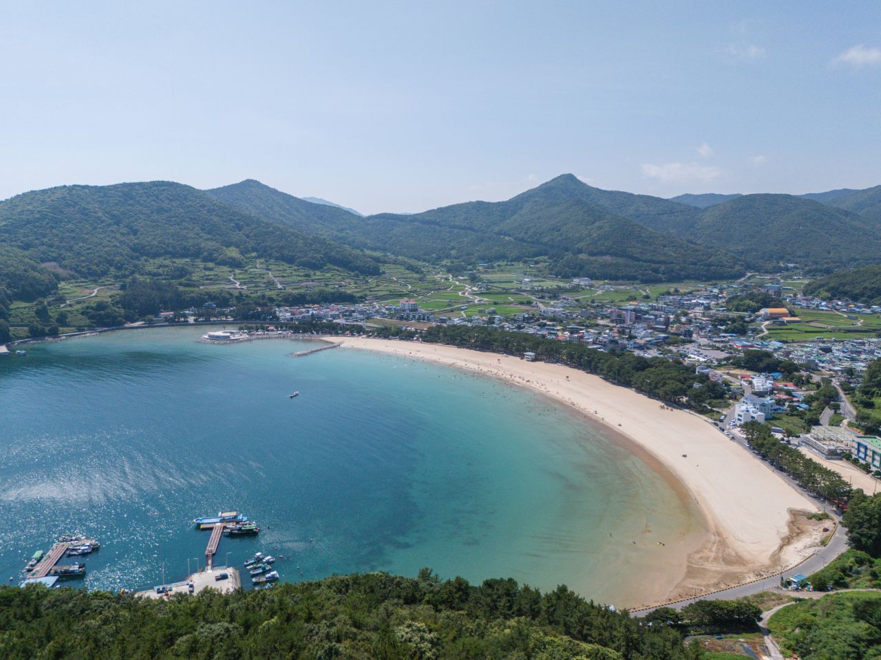 하늘에서 내려다본 상주은모래비치 — 금산 아래 초승달처럼 휜 백사장과 포구