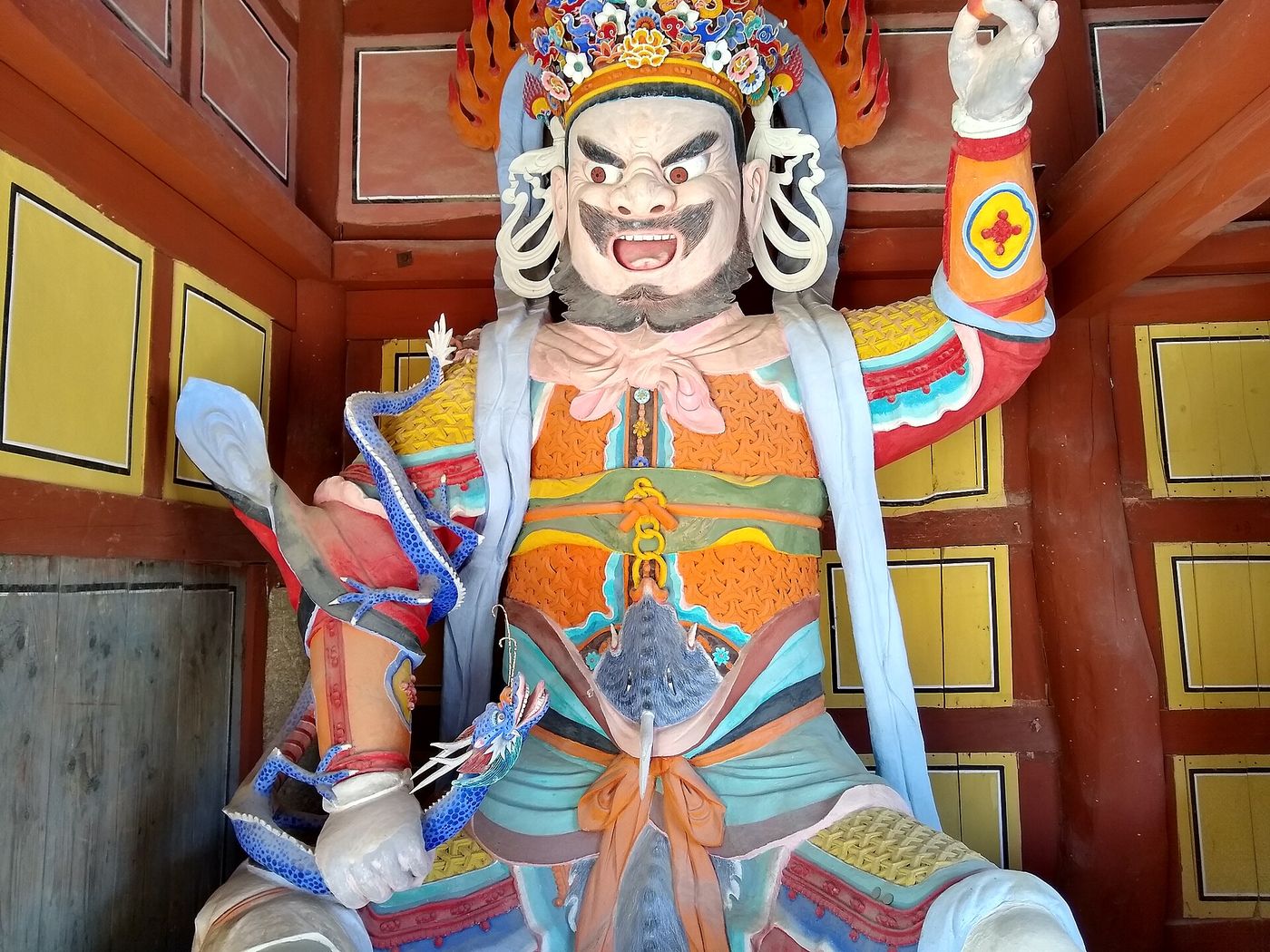 선운사 천왕문을 지키는 사천왕상 — 부릅뜬 눈과 화려한 갑옷, 손에 쥔 용이 생생하게 조각되었다