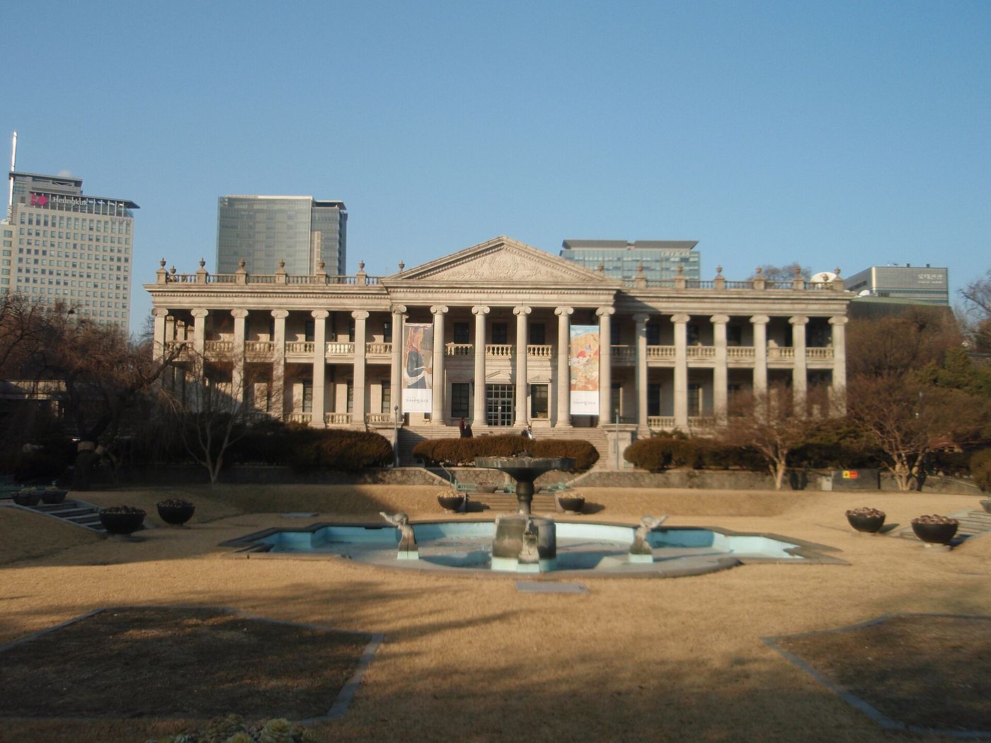 석조전과 도심 — 옛 석조 건물 너머로 빌딩이 솟아 옛것과 새것이 한 화면에 담긴다
