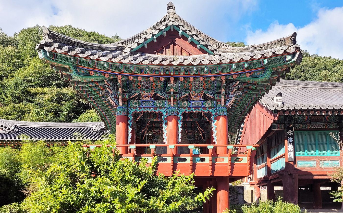 신흥사 경내 — 단청을 입힌 전통 사찰 누각이 바위산을 배경으로 앉아 있다