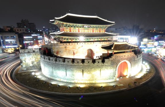 조명이 들어온 수원 화성 팔달문 야경 — 검은 성돌 위로 번지는 단청 불빛