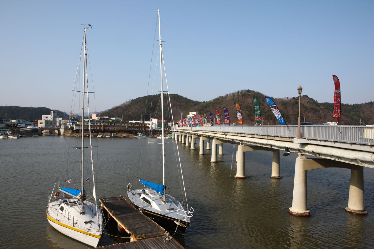 강구 오십천 하구의 강구대교 — 대게 축제 깃발이 늘어선 영덕 바다 여행의 관문